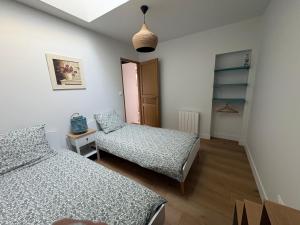 a bedroom with two beds and a closet at Maison de charme centre Pornic in Pornic
