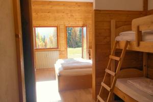 a room with two bunk beds and two windows at Valles Vacanze - ski in & ski out in Falcade