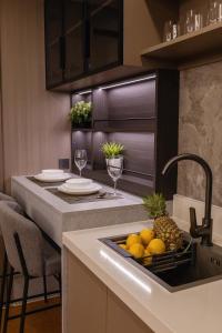 a kitchen with a sink with a bowl of fruit at 1BR Solice Apartment Capri in Ban Thalat Choeng Thale