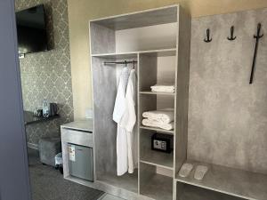 a bathroom with a closet with towels and a sink at Khan Boutique Hotel in Almaty
