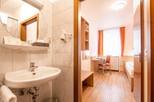 a white bathroom with a sink and a bedroom at Hotel Zur Traube in Velbert +35 photos
