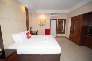 a hotel room with a large bed and a television at Brevant Pool Club and Resort in El Salvador