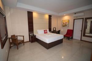 a hotel room with a bed and two chairs at Brevant Pool Club and Resort in El Salvador