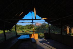 a building with a view of a mountain in the distance at The Sigiriya Rock Gate Chalet in Sigiriya