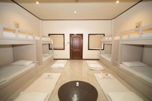 a room with four bunk beds and a table at Brevant Pool Club and Resort in El Salvador +24 photos