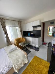 a bedroom with a bed and a chair and a table at Luxore Apartments Syokimau No E803 in Syokimau
