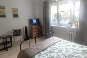 a bedroom with a bed and a television and a table at Smart Centrum in Konin