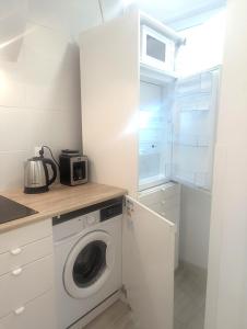a kitchen with a washing machine and a microwave at Smart Centrum in Konin +5 photos