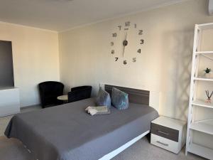 a bedroom with a bed and a clock on the wall at Apartments on Priportovaya,35 in Cherkasy