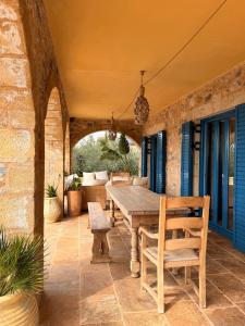 an outdoor patio with a wooden table and chairs at Pantazi Beach House in Kotrónion