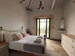 a bedroom with a bed and a large window at Pantazi Beach House in Kotrónion +14 photos
