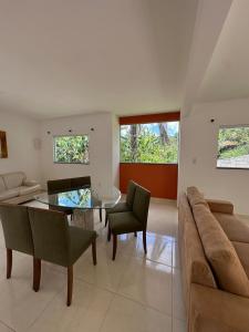 a living room with a glass table and a couch at Casinha da Val in Atibaia