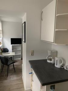 a kitchen with white cabinets and a black counter top at Cityperle Apartment in Erfurt