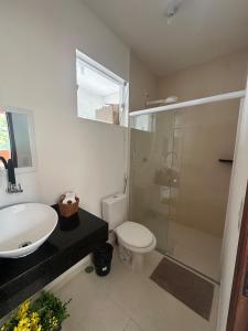a bathroom with a sink and a toilet and a shower at Casinha da Val in Atibaia +32 photos