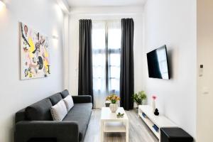 a living room with a couch and a window at Central Suites Aegina 1 in Egina