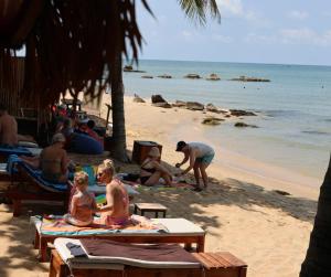 a group of people sitting on the beach at Êlim House in Phú Quốc