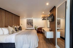 a bedroom with a large bed and a desk at Shelanti Guesthouse in Ceres