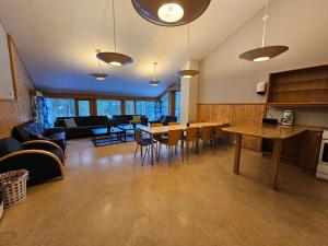 a room with a table and chairs and a living room at Alta Folkehøgskole in Alta