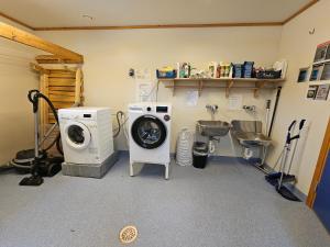 a laundry room with a washing machine and a sink at Alta Folkehøgskole in Alta