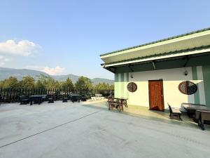 a patio with benches and tables and a fence at Khaochamao View in Ban Nam Pen