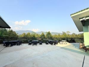 a patio with ping pong tables and a fence at Khaochamao View in Ban Nam Pen