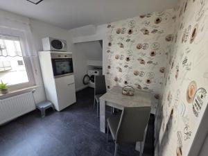 a kitchen with a table and chairs in a room at Haus Perla in Saarburg +10 photos