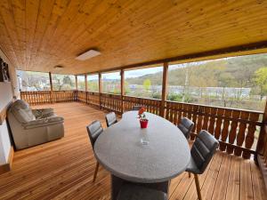 a room with a table and chairs on a deck at Haus Perla in Saarburg