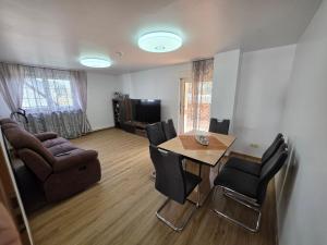 a living room with a dining room table and chairs at Haus Perla in Saarburg