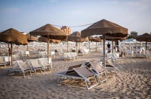a group of chairs and umbrellas on a beach at 5 Viale Fano Apartment in Rimini