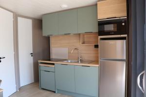 a kitchen with a sink and a refrigerator at Chalet Confort 49 in Rivières