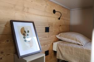 a bedroom with a bed and a picture on a table at Chalet Confort 49 in Rivières
