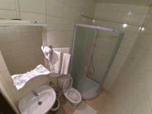 
a bathroom with a toilet, sink, and shower stall at Podvorye Hotel in Tula
