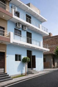 a blue building with balconies on the side of it at anandam stay in Vrindāvan