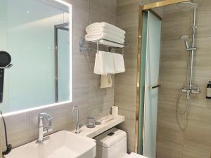 a bathroom with a sink and a mirror and a shower at Inner Mongolia Hotel Beijing - 300m to CUC Metro, Easy Access to Forbidden City & Universal Studios in Beijing