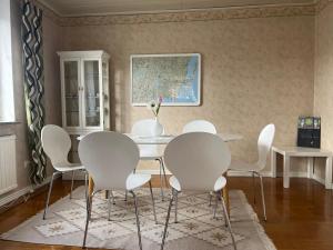 a dining room with white chairs and a table at Ferienhaus in Orrefors in Orrefors