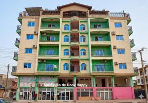 a tall building with the words shades of do down happy at 2 chambres residence Dovv quartier Odja in Yaoundé