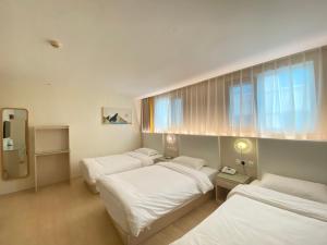 a room with three beds and a window at Inner Mongolia Hotel Beijing - 300m to CUC Metro, Easy Access to Forbidden City & Universal Studios in Beijing