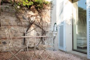 a pair of chairs sitting next to a stone wall at Casa Utopia in Santarcangelo di Romagna