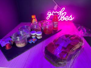a table with jars of food and a neon sign at Spa love room in Donges
