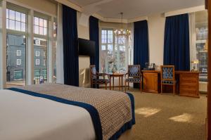 a bedroom with a bed and a table and chairs at Dikker & Thijs Hotel in Amsterdam