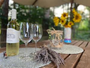 a bottle of wine and wine glasses on a table at Glamping Nad Meandry in Unhošť