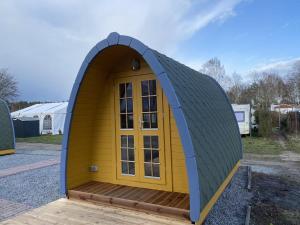 a small dog house with a yellow door at Themencamping Grünewalder Lauch in Grünewalde