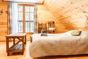 a bedroom with a bed and a wooden ceiling at Vējciems in Liepene