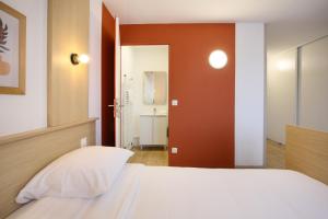 a bedroom with a white bed and a bathroom at Sweetly Isatis Mérignac Hôtel de ville in Mérignac