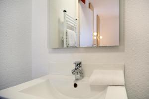 a bathroom with a white sink and a mirror at Sweetly Isatis Mérignac Hôtel de ville in Mérignac +30 photos