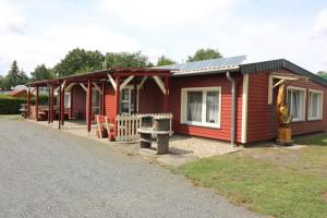 a small red house with a solar roof at Themencamping Grünewalder Lauch in Grünewalde