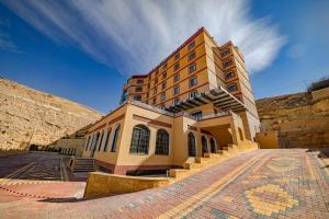 a building with stairs in front of a mountain at Petra Canyon Hotel in Wadi Musa