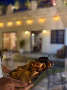 a person holding a plate with food on it at Asmi by Beal's Farm in Jaipur