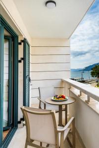 a table and chairs on a balcony with a view of the ocean at Boutique Hotel Villa Royal in Tivat
