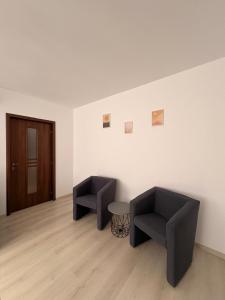a room with two chairs and a table and a door at Comodo Apartment in Turda